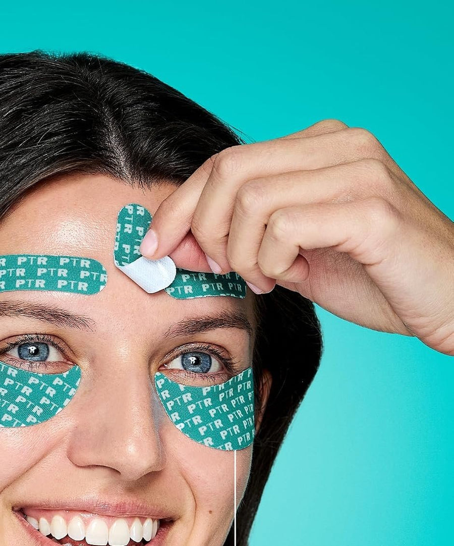 Mujer sonriendo con cintas en la frente y bajo los ojos